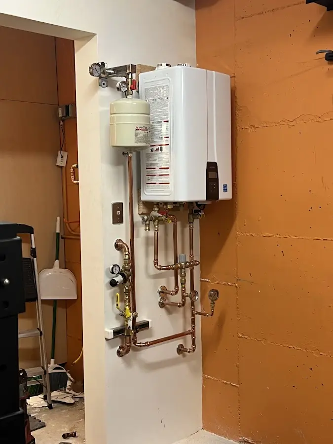 Plumbing technician inspecting water heater connections in Cornelius
